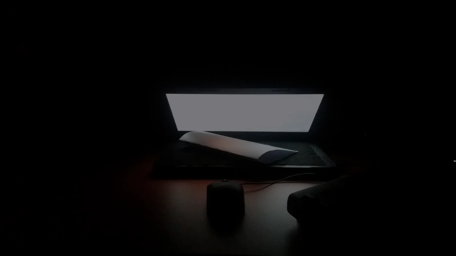 A laptop and workspace desk at night